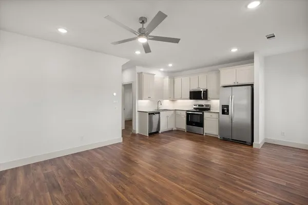 a kitchen with granite countertop a refrigerator and a stove top oven