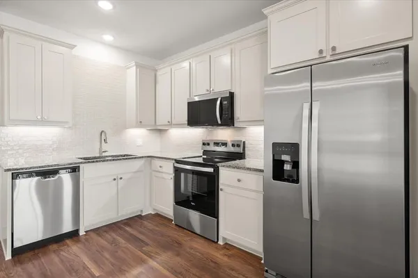 a kitchen with stainless steel appliances a stove microwave and refrigerator