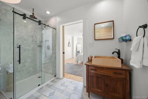 a bathroom with a tub sink and mirror