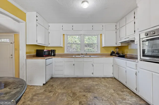 a kitchen with cabinets appliances and a window
