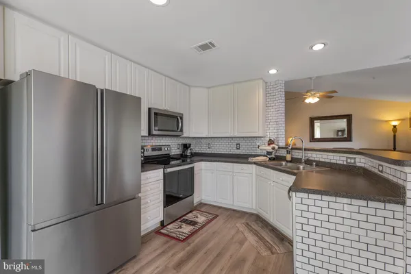 a kitchen with stainless steel appliances a refrigerator sink and microwave