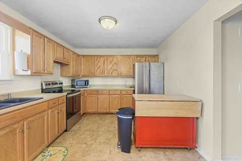 a kitchen with stainless steel appliances granite countertop a stove a sink and a refrigerator