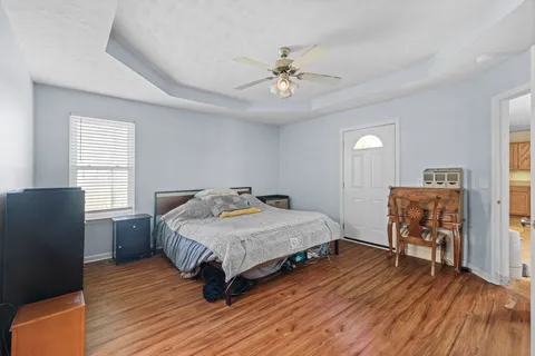 a bedroom with a bed and wooden floor