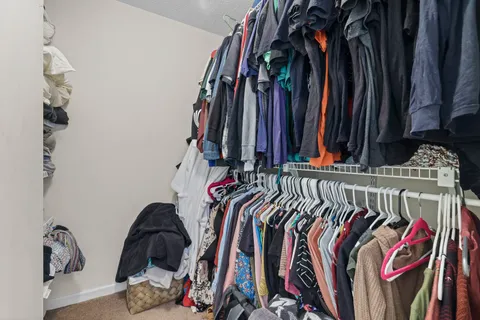 a view of walk in closet with clothes