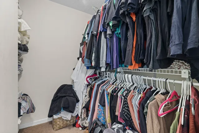 a view of walk in closet with clothes