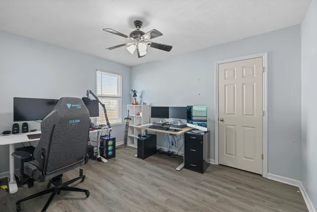 a view of a workspace with furniture and wooden floor