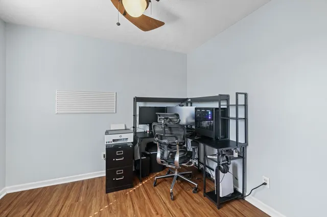 a view of a workspace with furniture and wooden floor