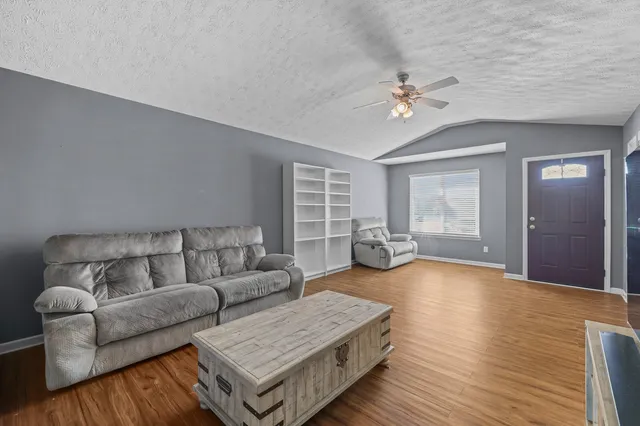 a living room with furniture and wooden floor