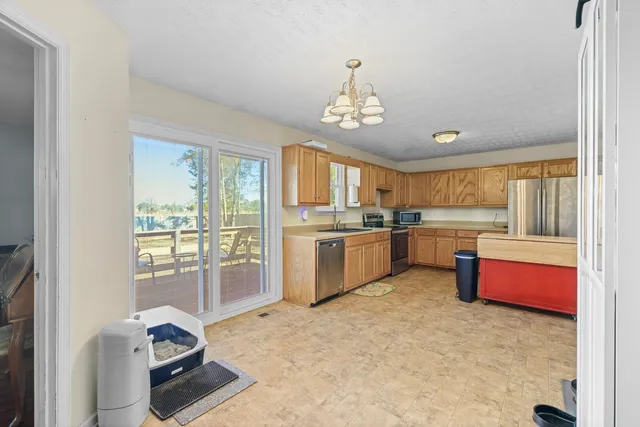a open kitchen with granite countertop a sink cabinets and stainless steel appliances