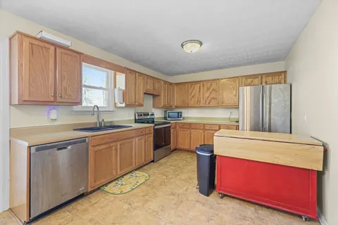 a kitchen with stainless steel appliances granite countertop a stove sink and cabinets