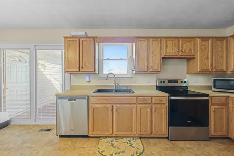 a kitchen with stainless steel appliances granite countertop a sink stove and cabinets