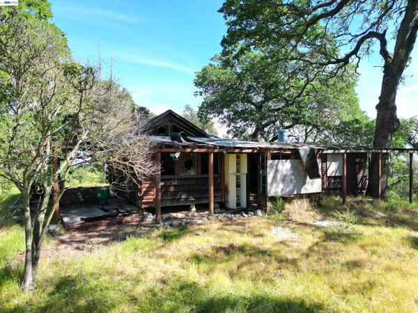 a view of house with backyard and seating area