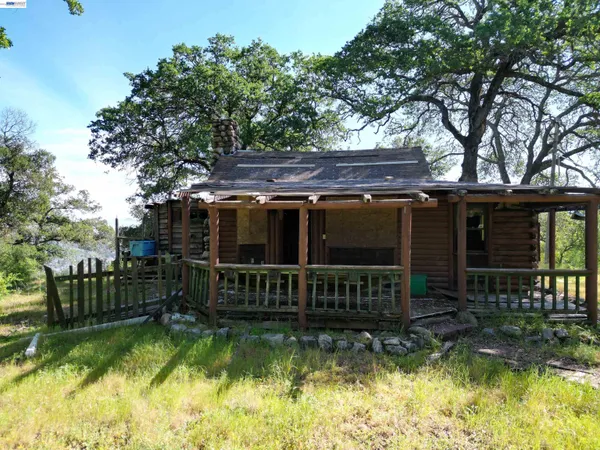 an aerial view of a houses with a lush green hillside
