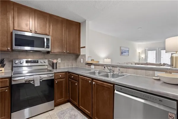 a kitchen with stainless steel appliances granite countertop a sink stove microwave and cabinets