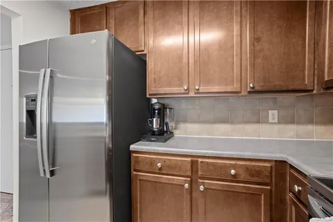 a kitchen with metallic refrigerator and cabinets