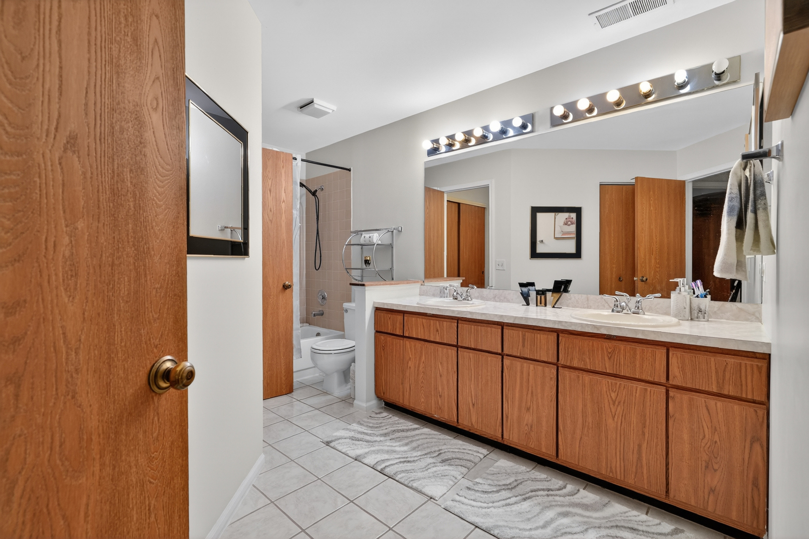 943 Ridgefield Lane, Unit 4 Wheeling, IL 60090 - Photo 13 of 38 a bathroom with a double vanity sink a mirror and a shower