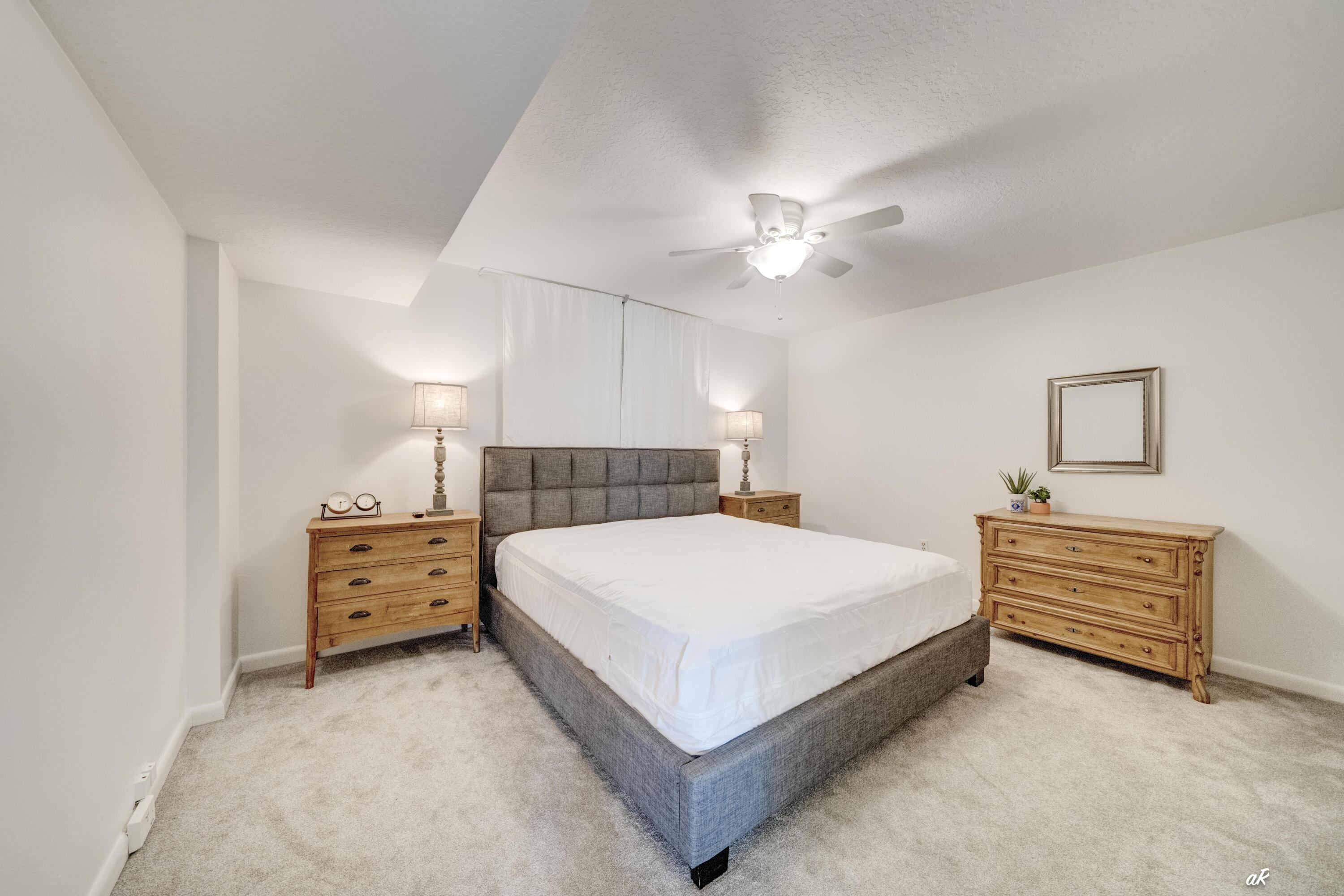 30 Moreno Point Road, Unit 404A Destin, FL 32541 - Photo 25 of 52 a spacious bedroom with a bed and a chandelier