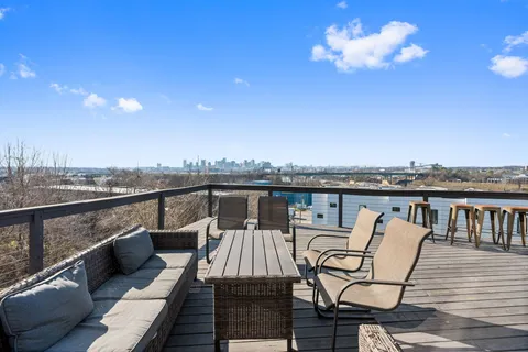 a view of a balcony with wooden floor and outdoor seating