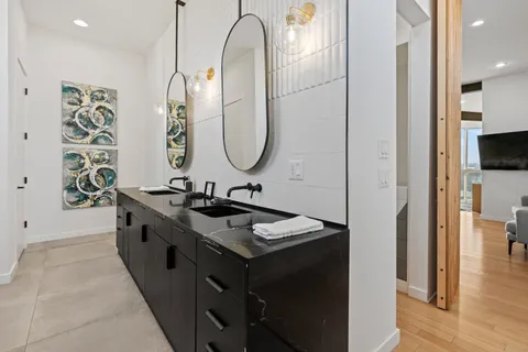 a en suite bathroom with a double vanity sink a mirror and a shower
