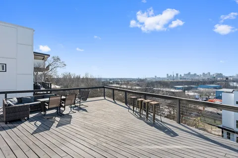 a view of a roof deck with couches and wooden floor
