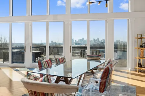 a view of a dining room with furniture large windows and wooden floor