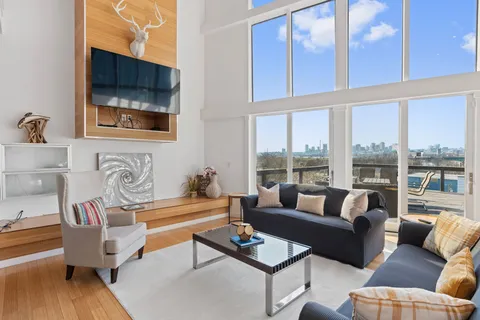 a living room with furniture and a floor to ceiling window
