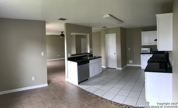 a kitchen with a refrigerator and a stove top oven