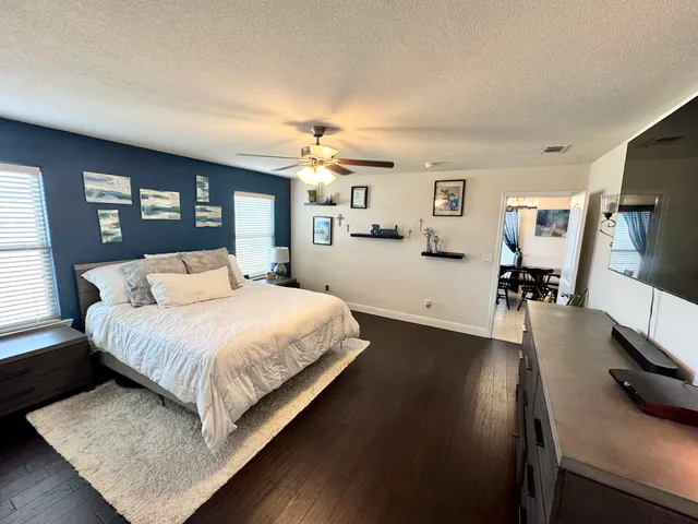 a spacious bedroom with a bed and wooden floor
