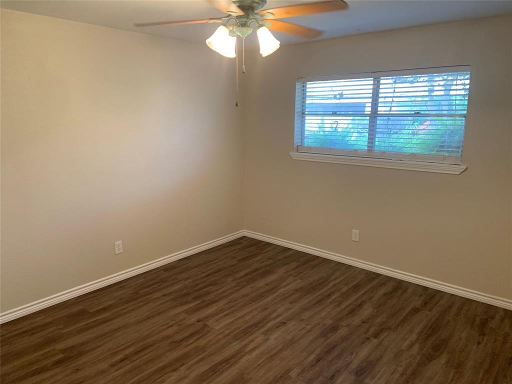 3302 Burke Road, Unit 9 Pasadena, TX 77504 - Photo 10 of 20 a view of an empty room with wooden floor and a window