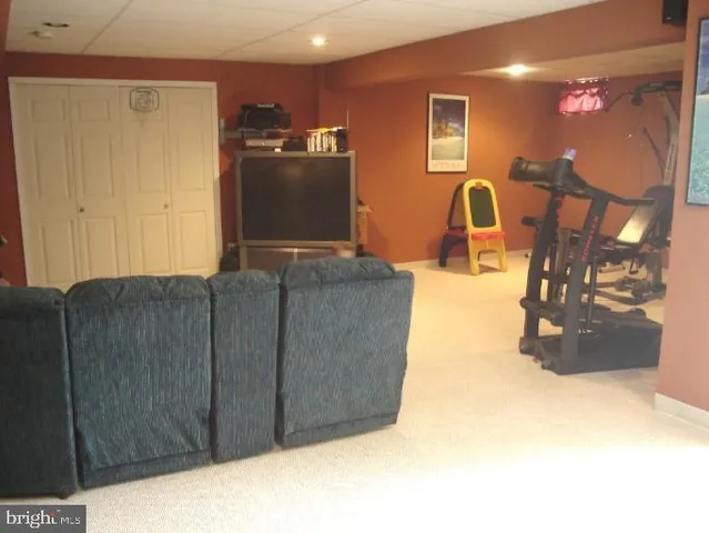 a living room with couches and projector with a flat screen tv
