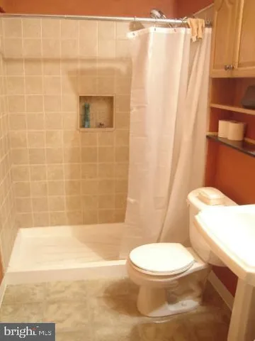 a white toilet sitting next to a bath tub