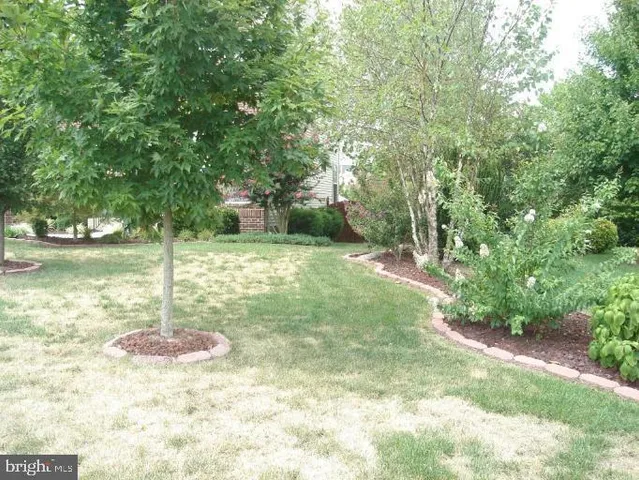 a backyard of a house with lots of green space and fountain