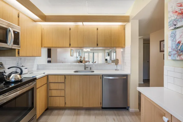 a kitchen with stainless steel appliances a sink stove and cabinets