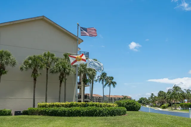 a front view of a house with a yard and potted plants