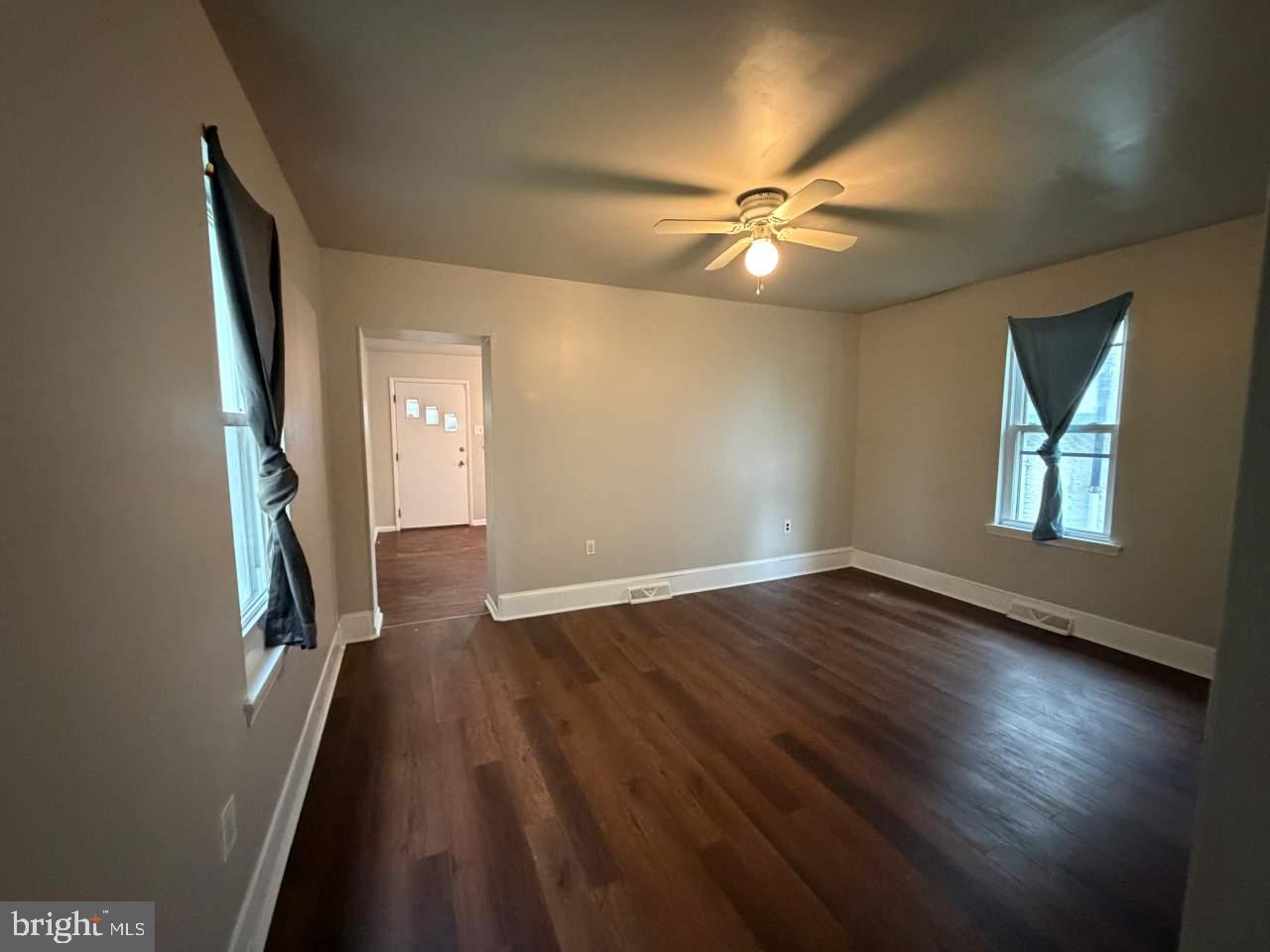 135 9th Street Brookhaven, PA 19015 - Photo 4 of 9 an empty room with wooden floor fan and windows