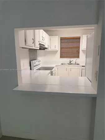 a close view of kitchen sink microwave and cabinets