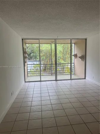 a view of an empty room with a floor to ceiling window and a window