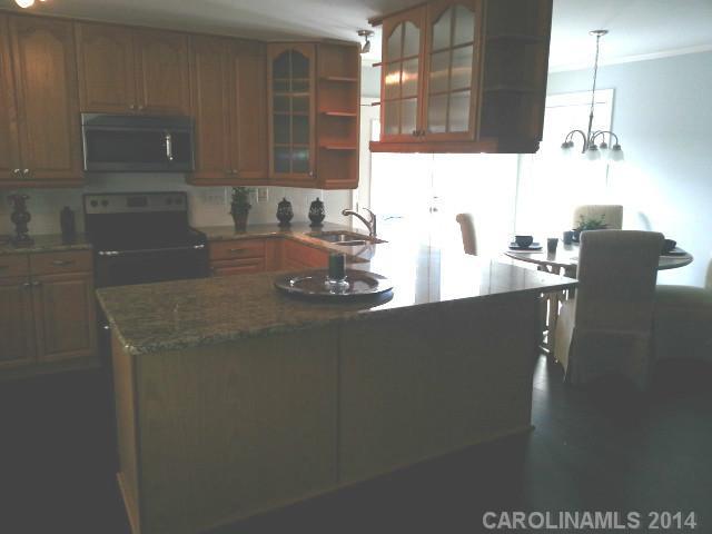 4605 Griffith Road Monroe, NC 28112 - Photo 4 of 16 a kitchen with a sink a stove and wooden cabinets