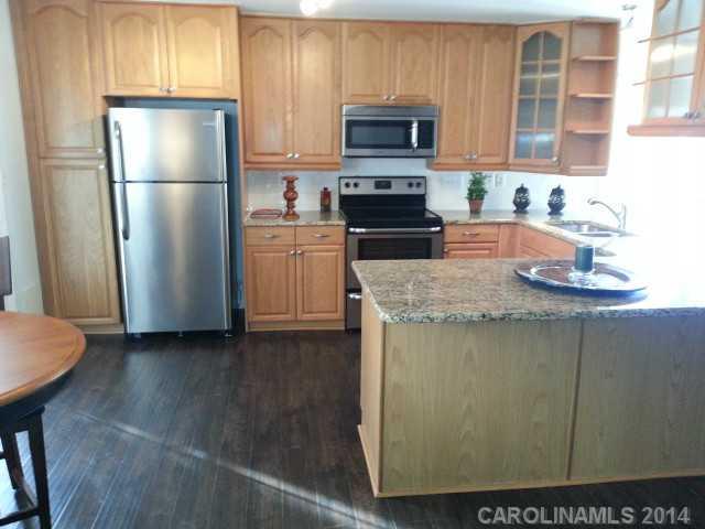 4605 Griffith Road Monroe, NC 28112 - Photo 5 of 16 a kitchen with granite countertop a refrigerator stove and microwave