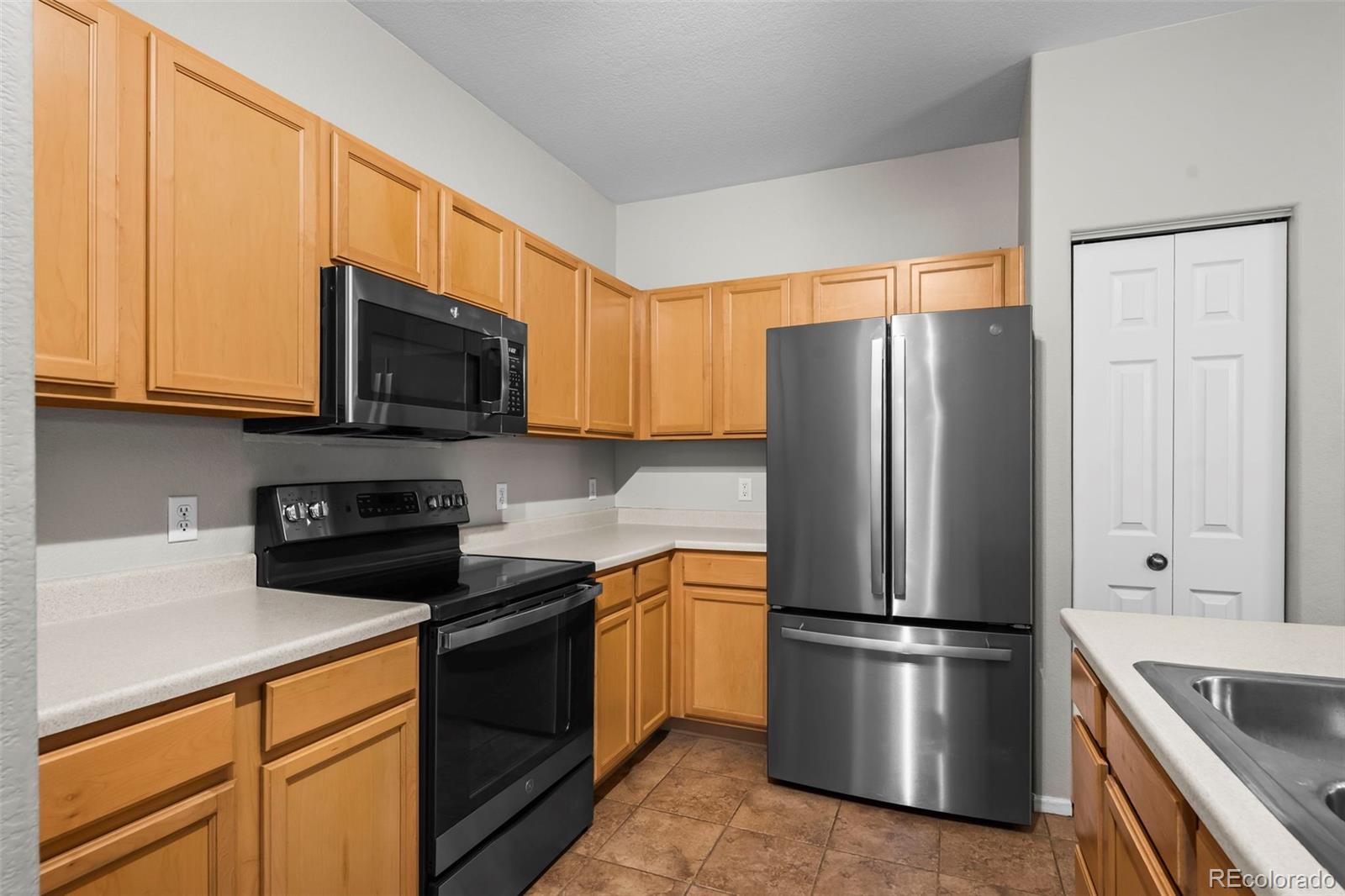 10787 Twenty Mile Road, Unit 301 Parker, CO 80134 - Photo 11 of 31 a kitchen with stainless steel appliances a refrigerator stove microwave and sink