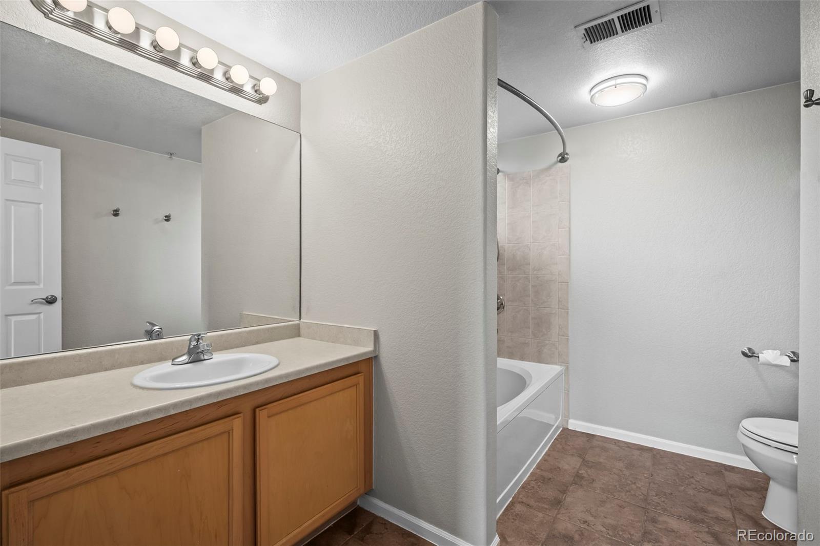 10787 Twenty Mile Road, Unit 301 Parker, CO 80134 - Photo 15 of 31 a bathroom with a sink a toilet and shower