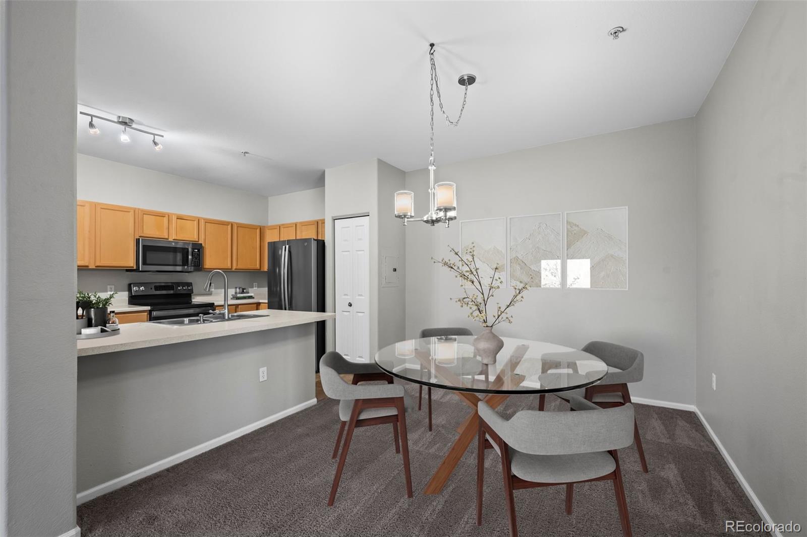 10787 Twenty Mile Road, Unit 301 Parker, CO 80134 - Photo 6 of 31 a kitchen with stainless steel appliances a dining table chairs and stove