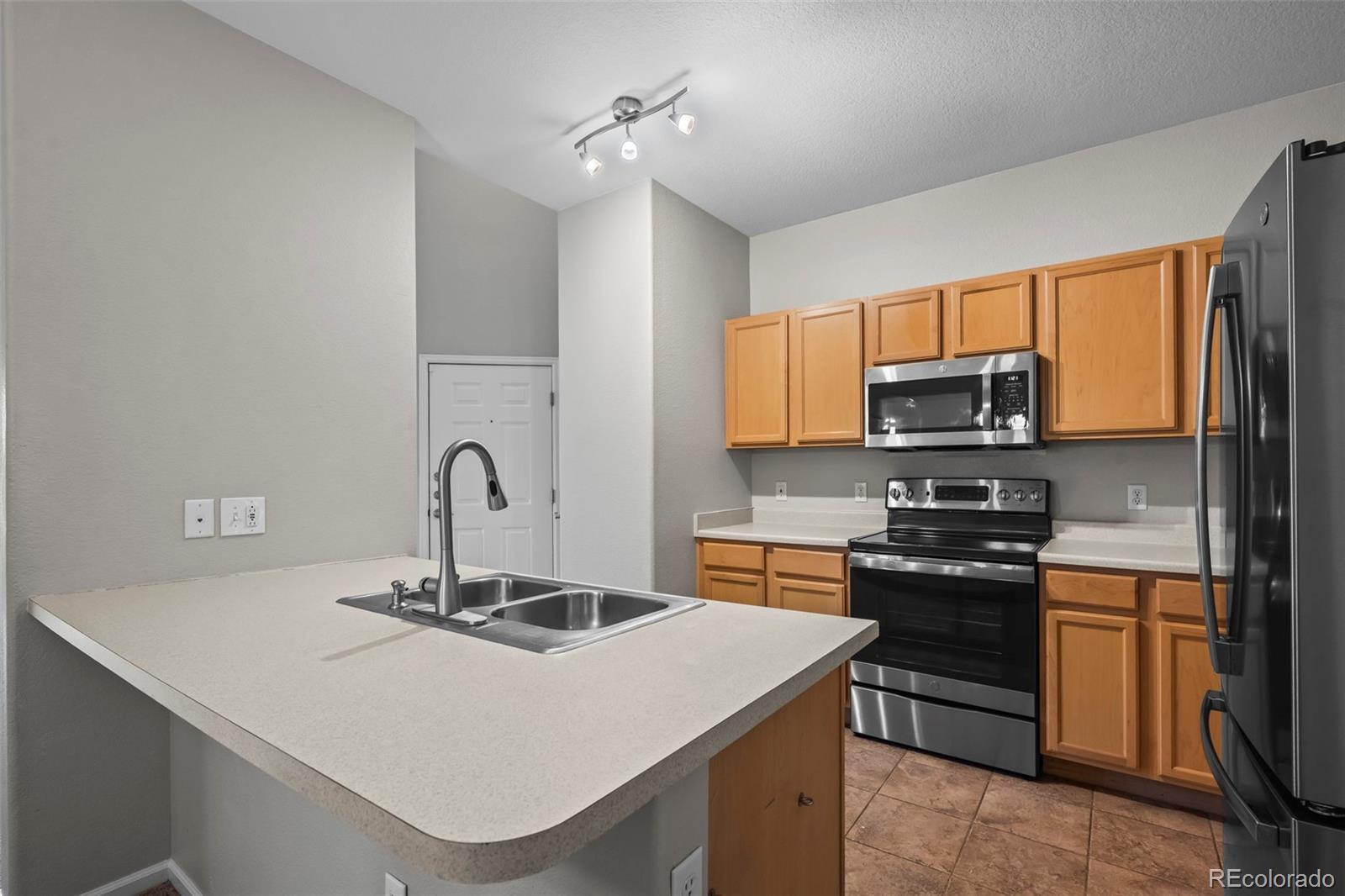 10787 Twenty Mile Road, Unit 301 Parker, CO 80134 - Photo 8 of 31 a kitchen with stainless steel appliances a sink stove and cabinets