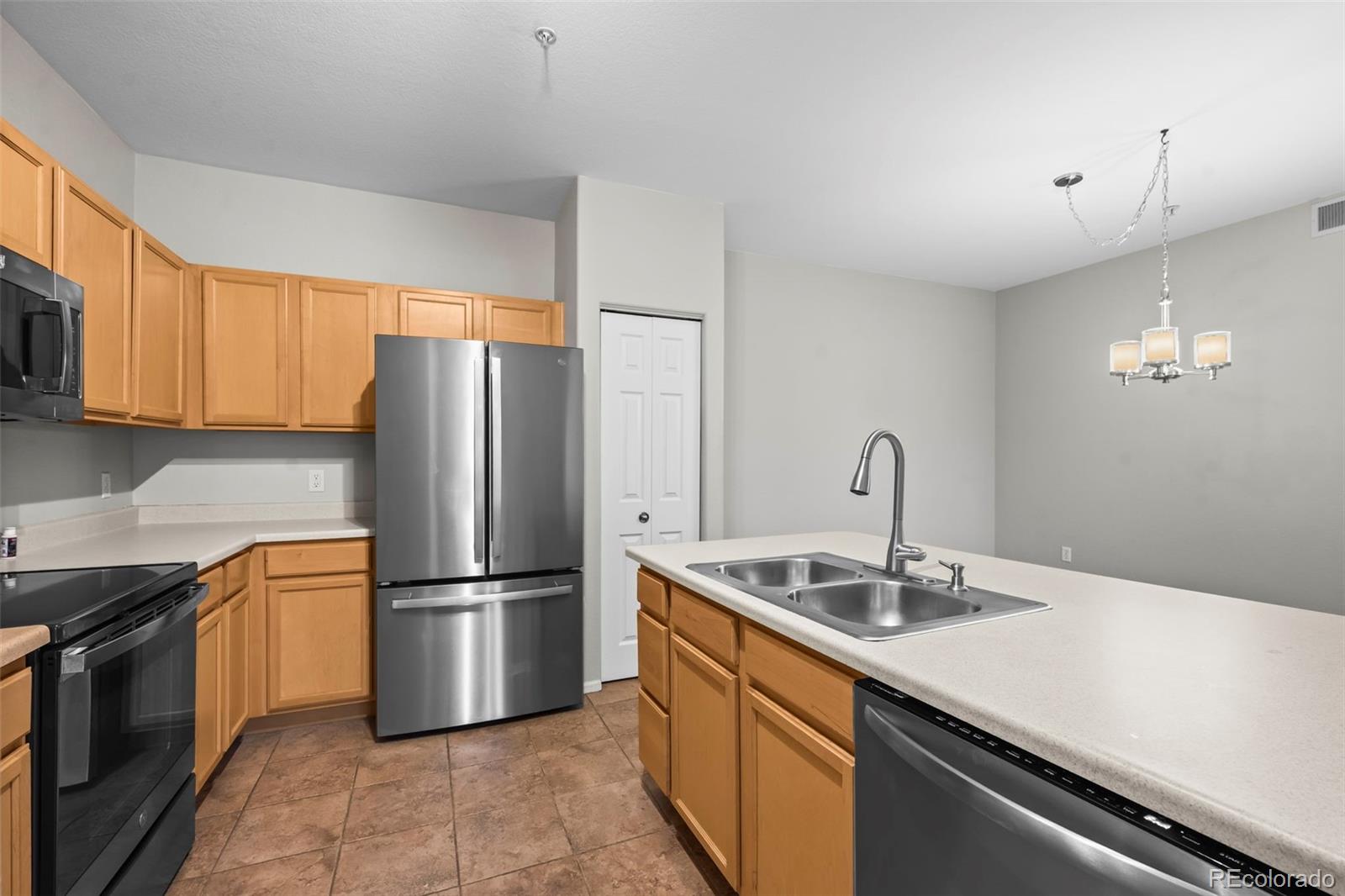 10787 Twenty Mile Road, Unit 301 Parker, CO 80134 - Photo 10 of 31 a kitchen with stainless steel appliances granite countertop a sink a stove a refrigerator and cabinets