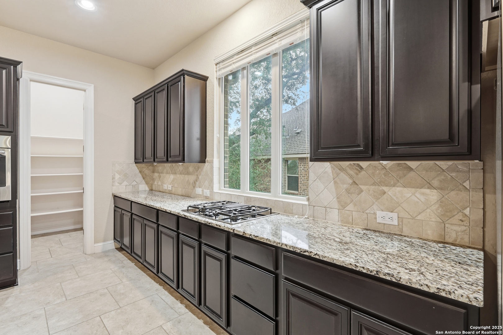 8234 Two Winds San Antonio, TX 78255 - Photo 17 of 37 a kitchen with stainless steel appliances granite countertop a sink stove and cabinets