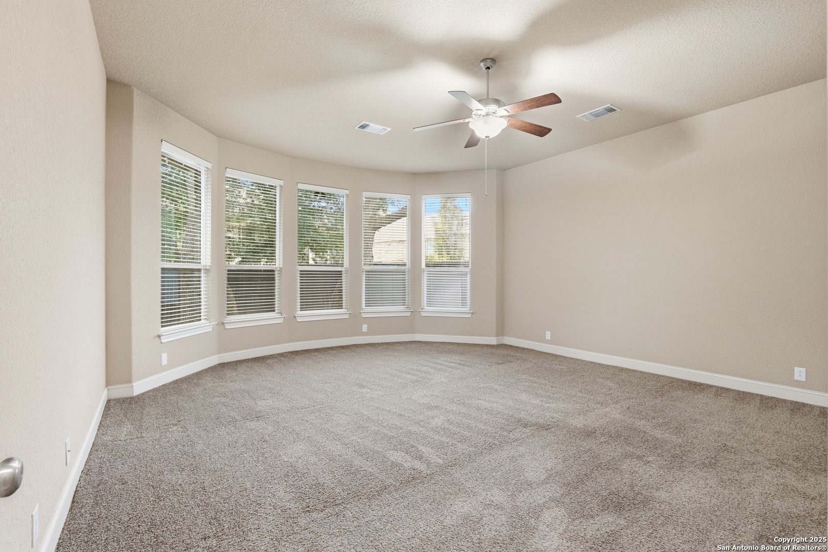 8234 Two Winds San Antonio, TX 78255 - Photo 19 of 37 an empty room with chandelier fan and windows