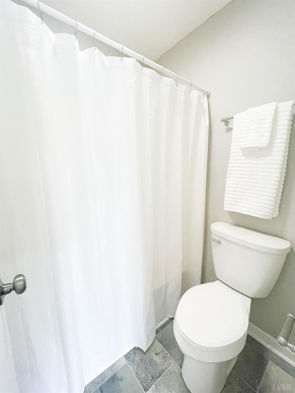 2222 Deer Run Forest, VA 24551 - Photo 26 of 44 a white toilet sitting next to a shower curtain