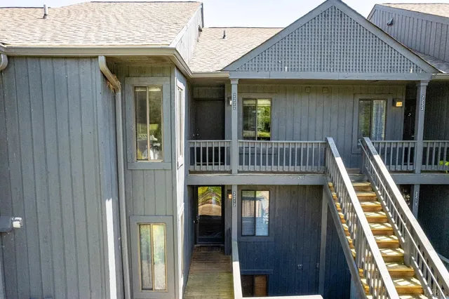 a view of a house with a big yard and potted plants