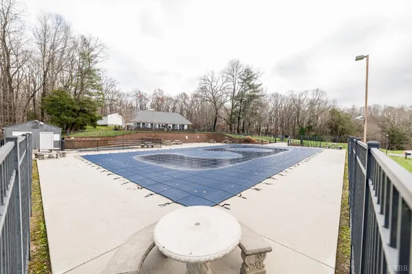a view of swimming pool with a big yard and large trees