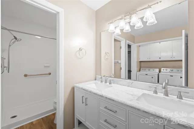 a bathroom with a granite countertop sink a mirror and a shower